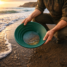 Beach gold panning scene with green pan and fine gold concentrates